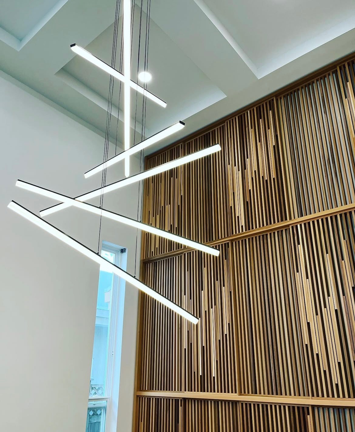 modern pendant LED fixture with wood slat wall